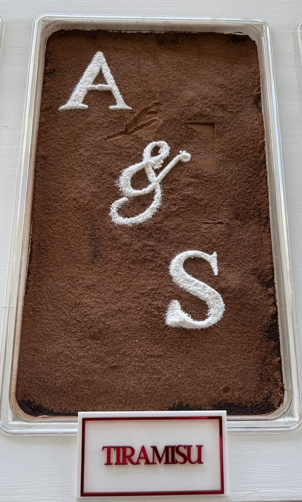 A tray of tiramisu dusted with a couple's initials